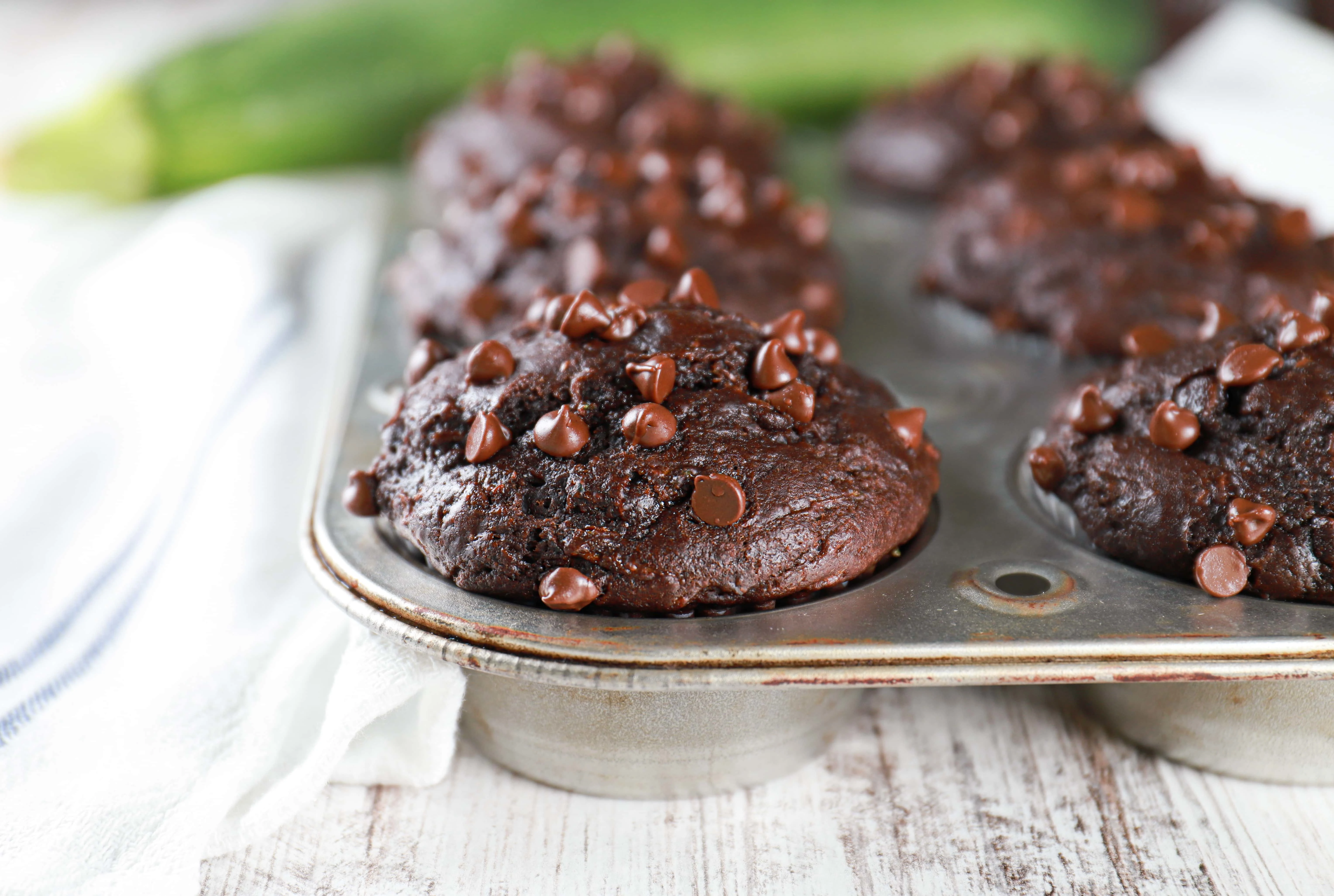 Up close side view of a bakery style double chocolate zucchini muffin. Recipe from A Kitchen Addiction