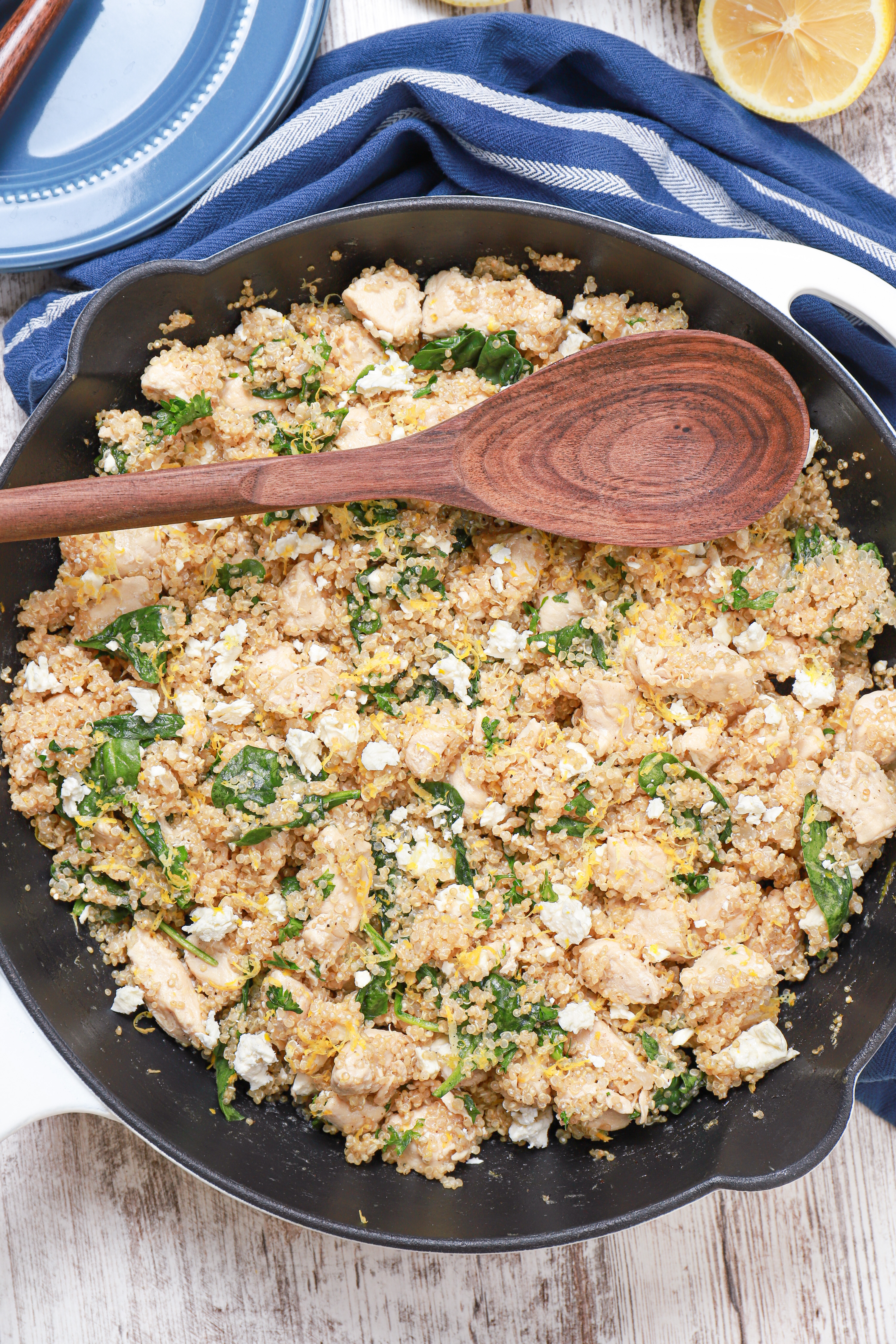 overhead view of a white cast iron skillet filled with lemon feta chicken quinoa skillet meal