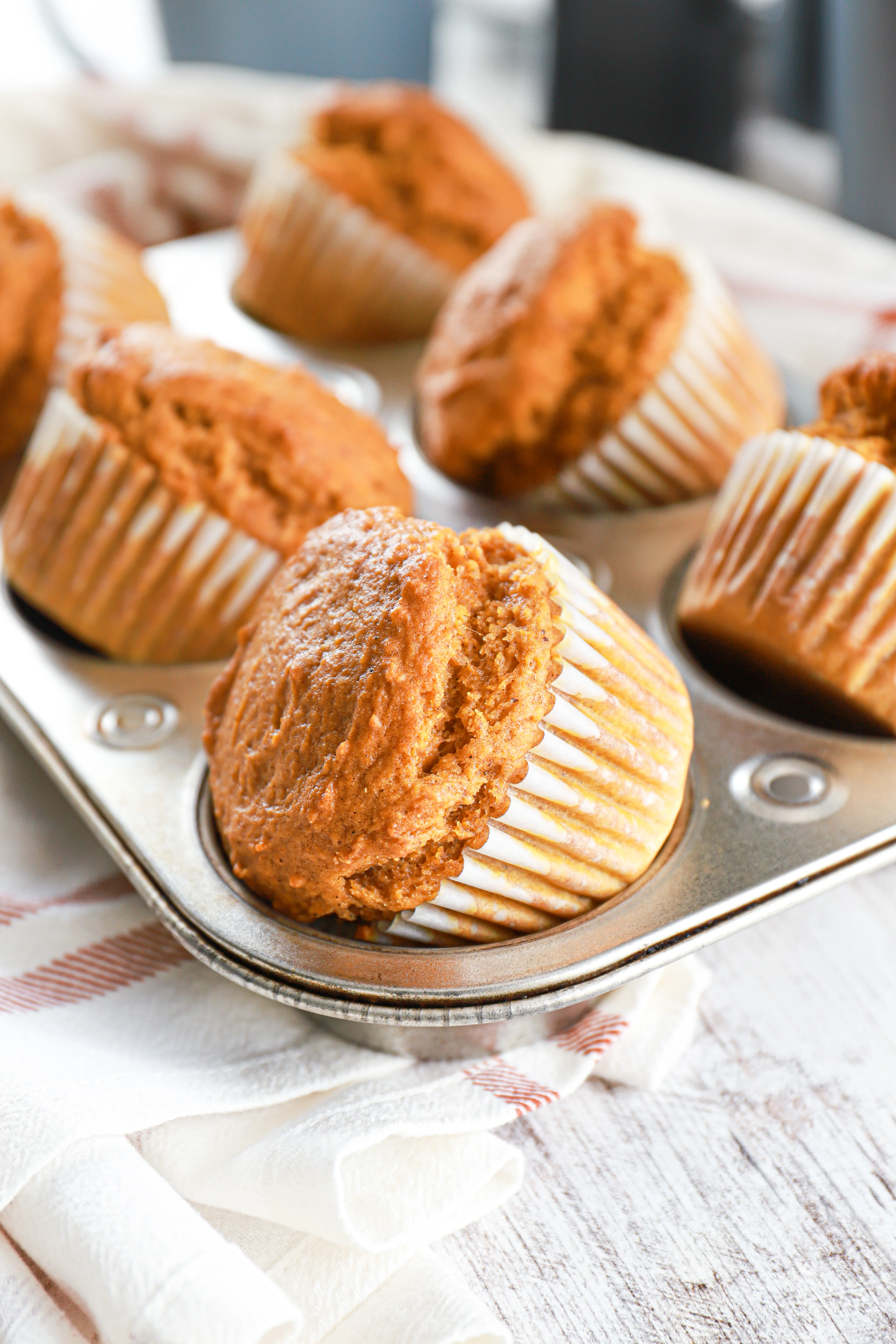 Side view of bakery style pumpkin muffins in a muffin tin