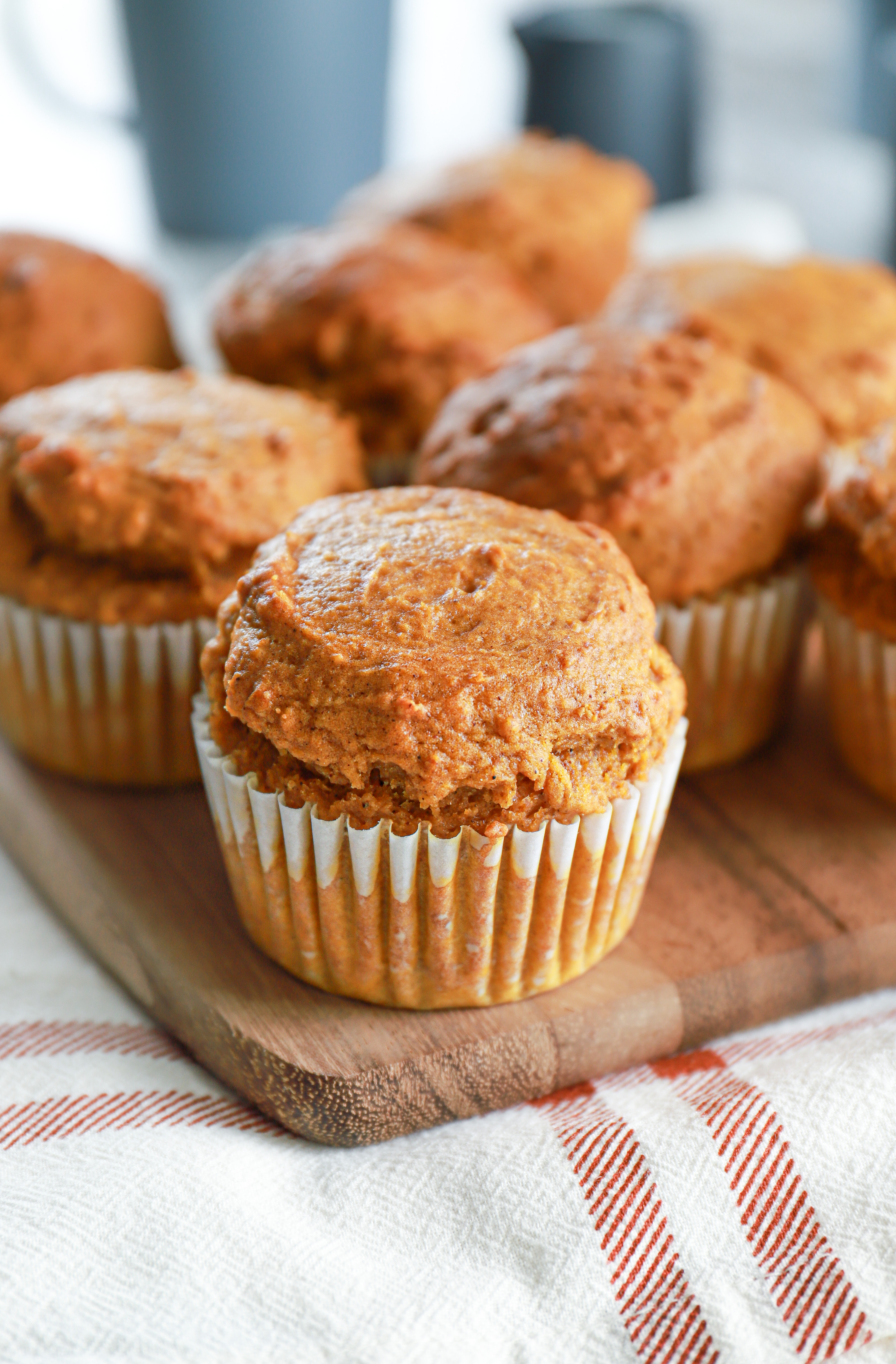 Up close view of a bakery style pumpkin muffin on a wooden cutting board