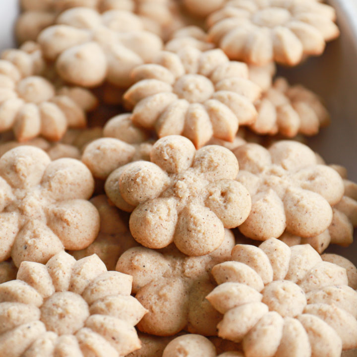 Up close angle view of a chai spritz cookie on a pile of cookies