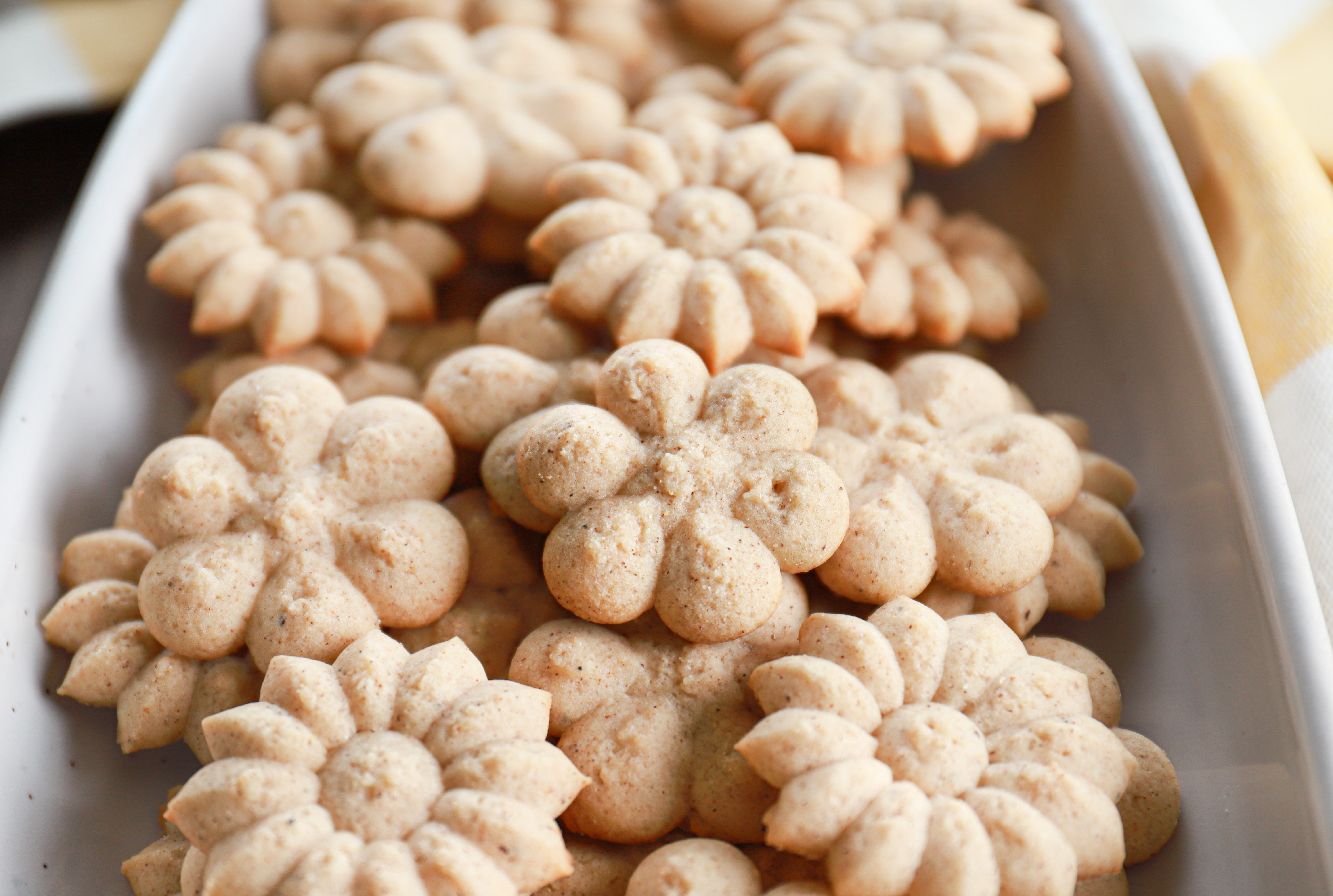 Up close angle view of a chai spritz cookie on a pile of cookies