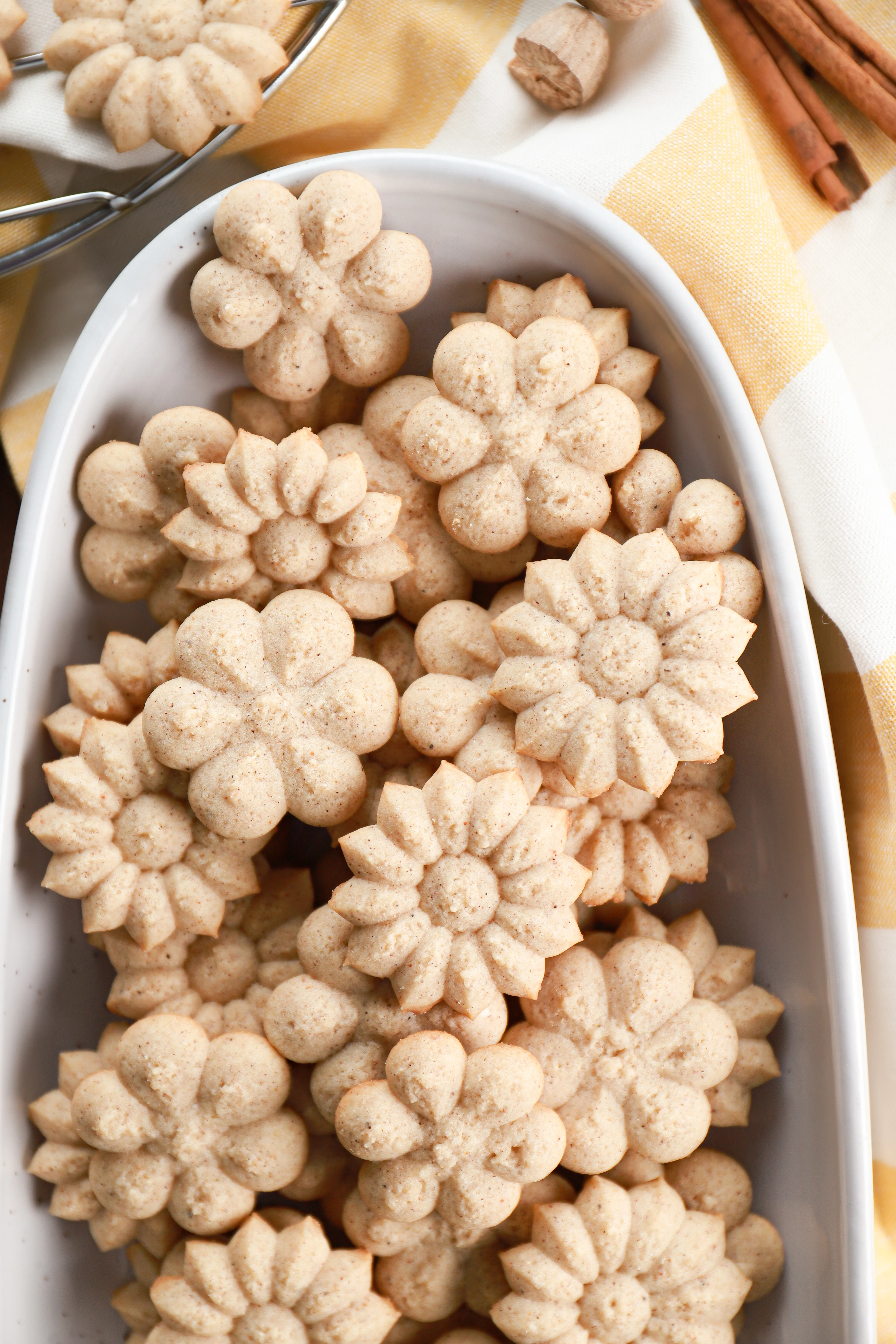 Above view of a batch of chai spice spritz cookies on an oblong white platter