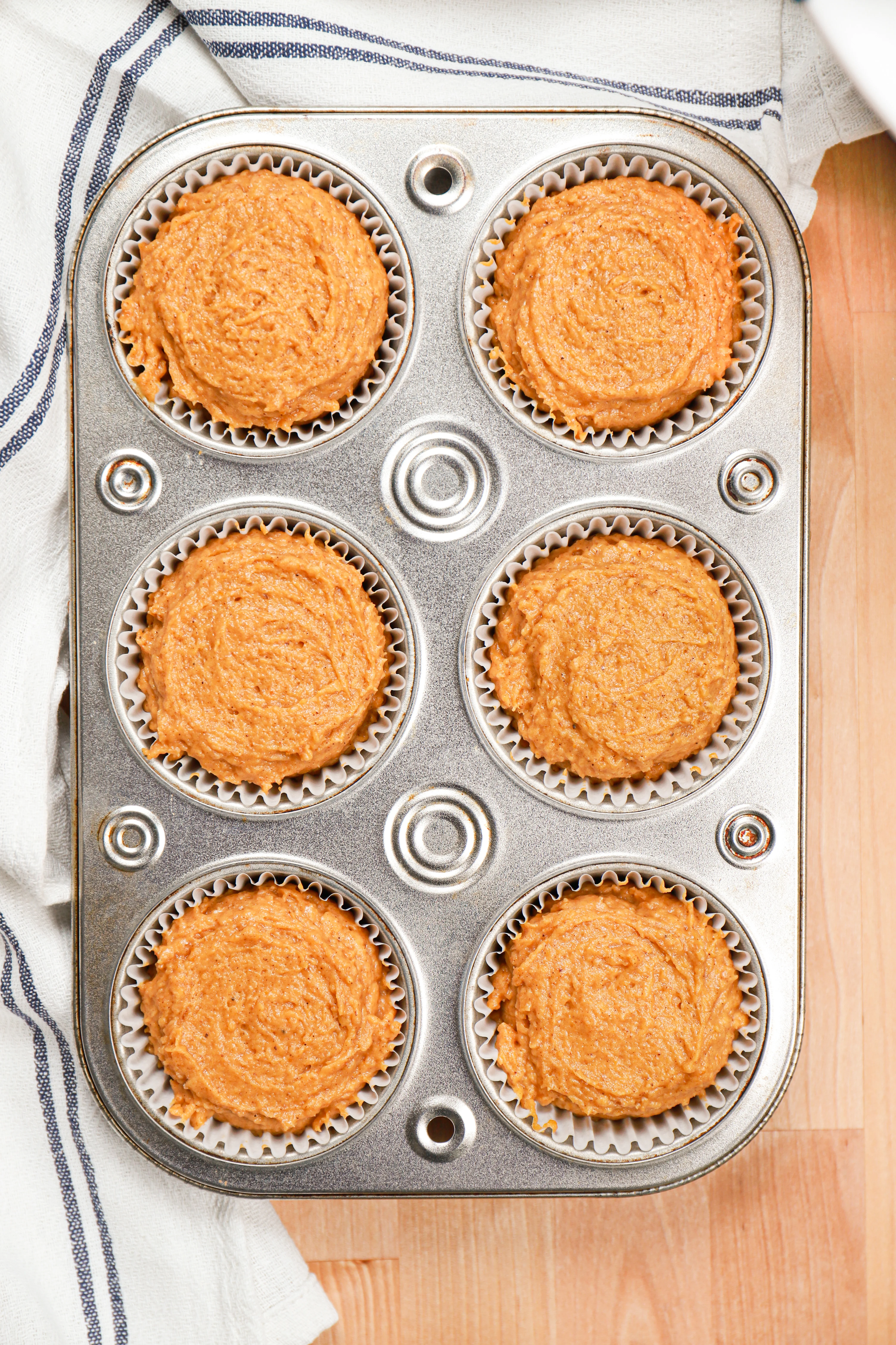 Pumpkin muffin batter in muffin tin