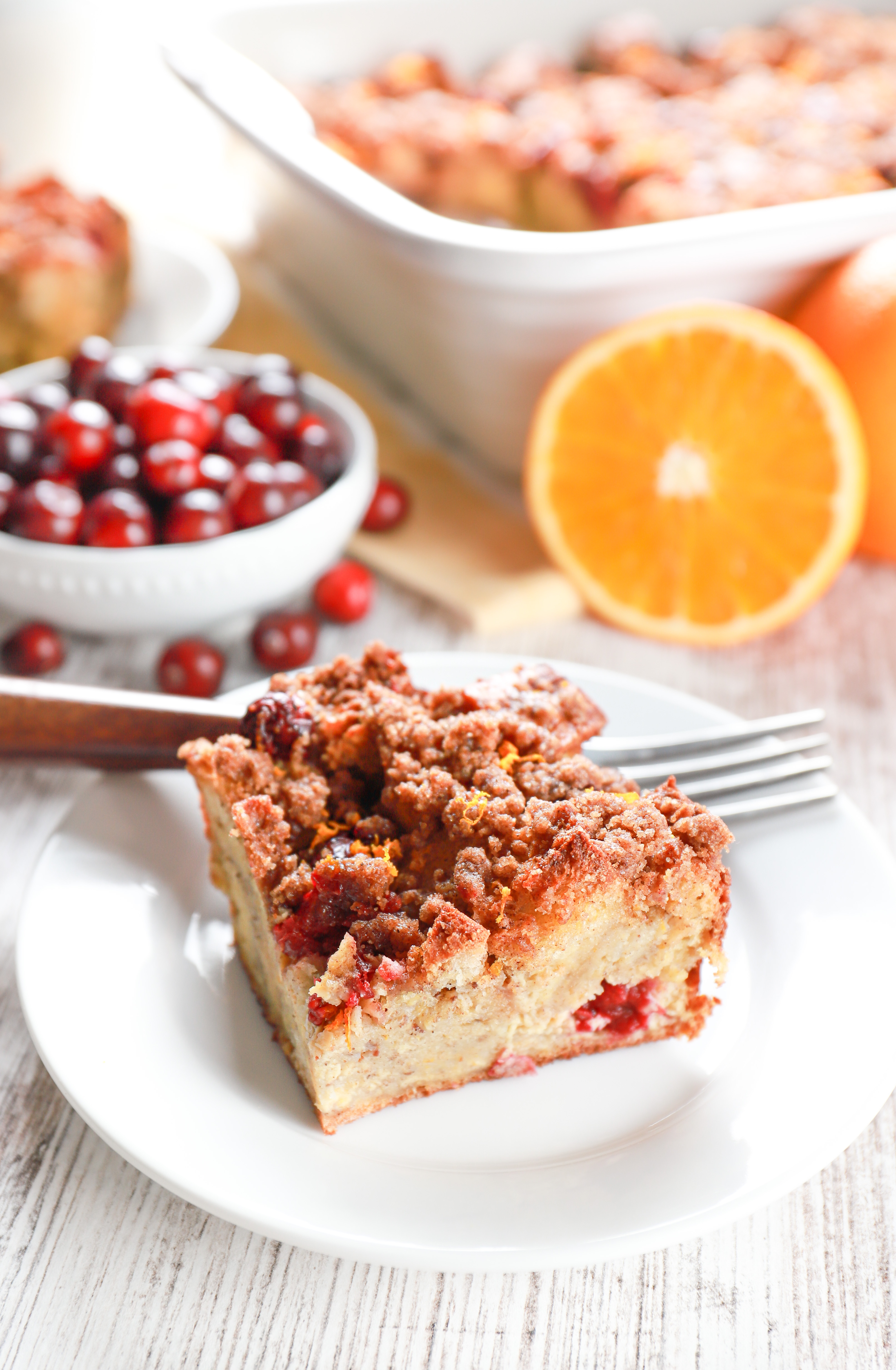 Slice of cranberry orange french toast bake on a small white plate.