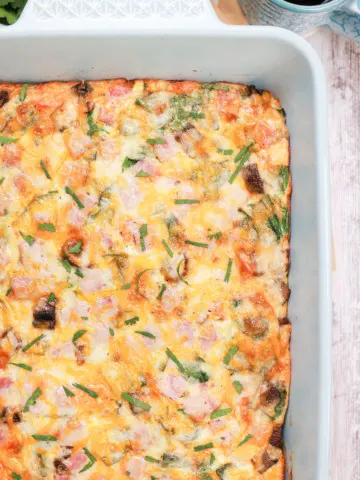 Up close overhead view of a batch of ham and cheese crescent roll breakfast bake in a light blue baking dish.