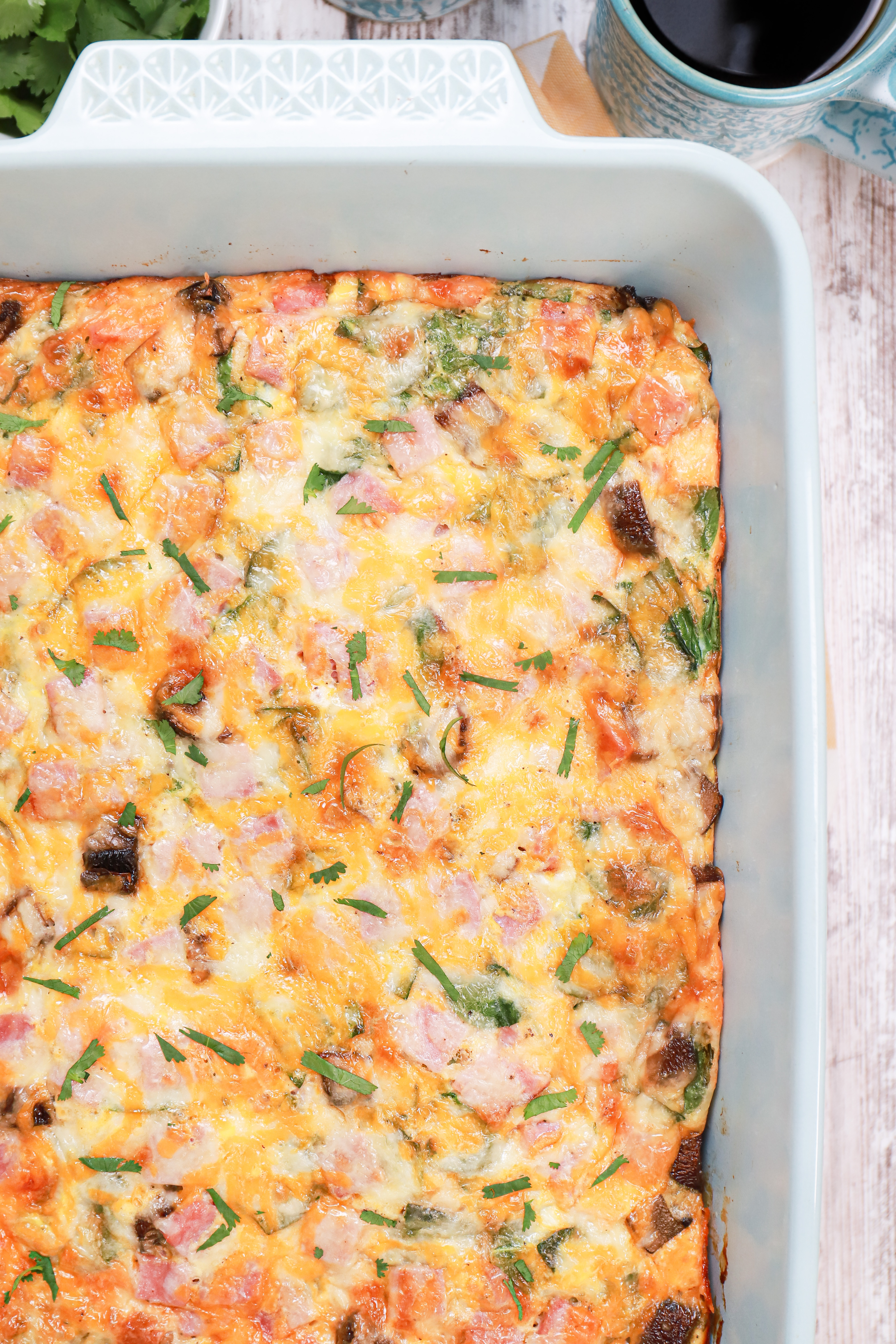 Up close overhead view of a batch of ham and cheese crescent roll breakfast bake in a light blue baking dish.