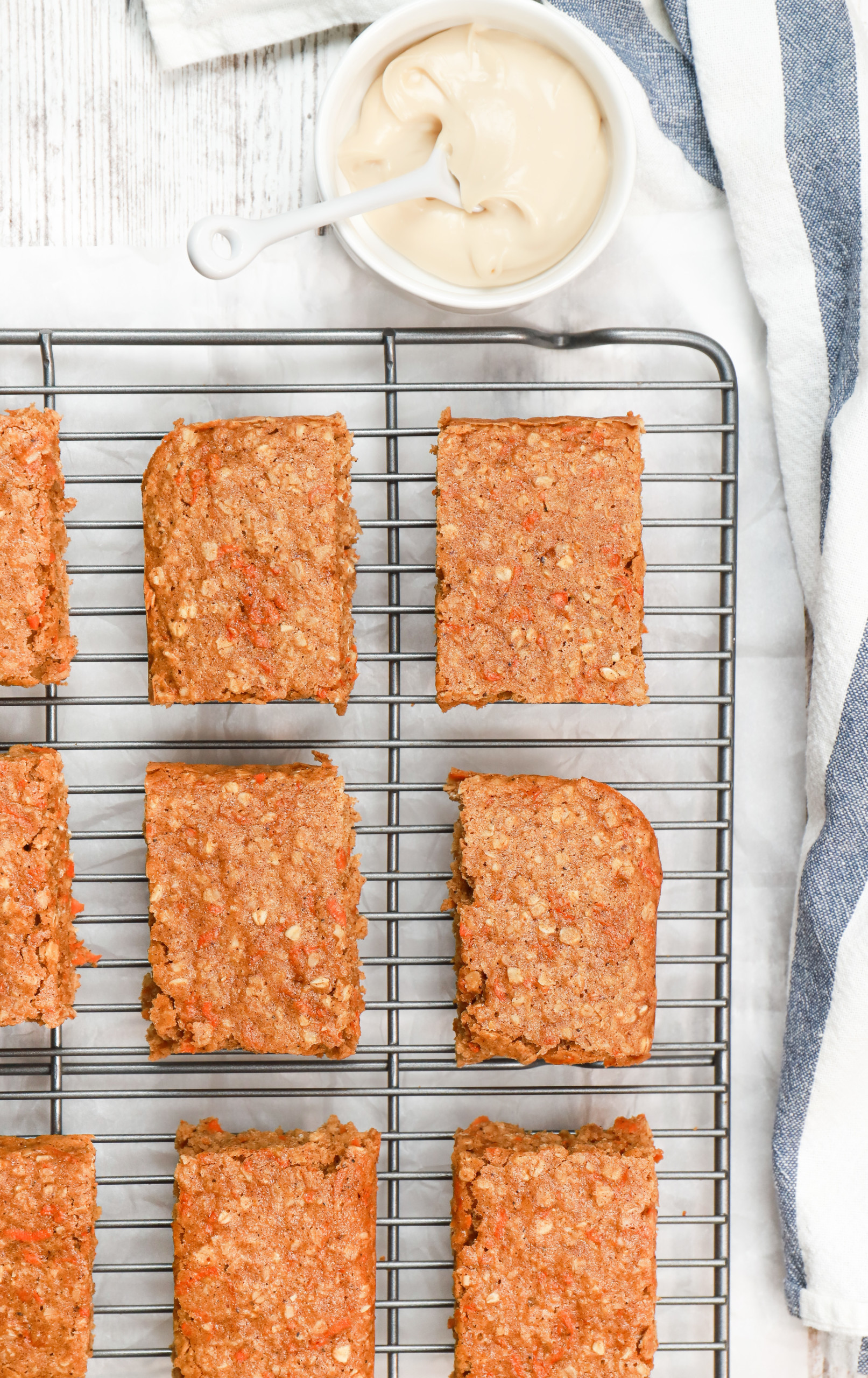 Overhead view of soft baked carrot cake oat bars on a cooling rack before drizzling with cream cheese glaze.