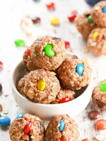 Up close overhead view of a small white bowl full of almond butter trail mix bites.