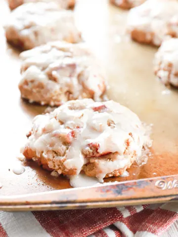 Side view of a baked rhubarb fritter on an aluminum baking sheet.