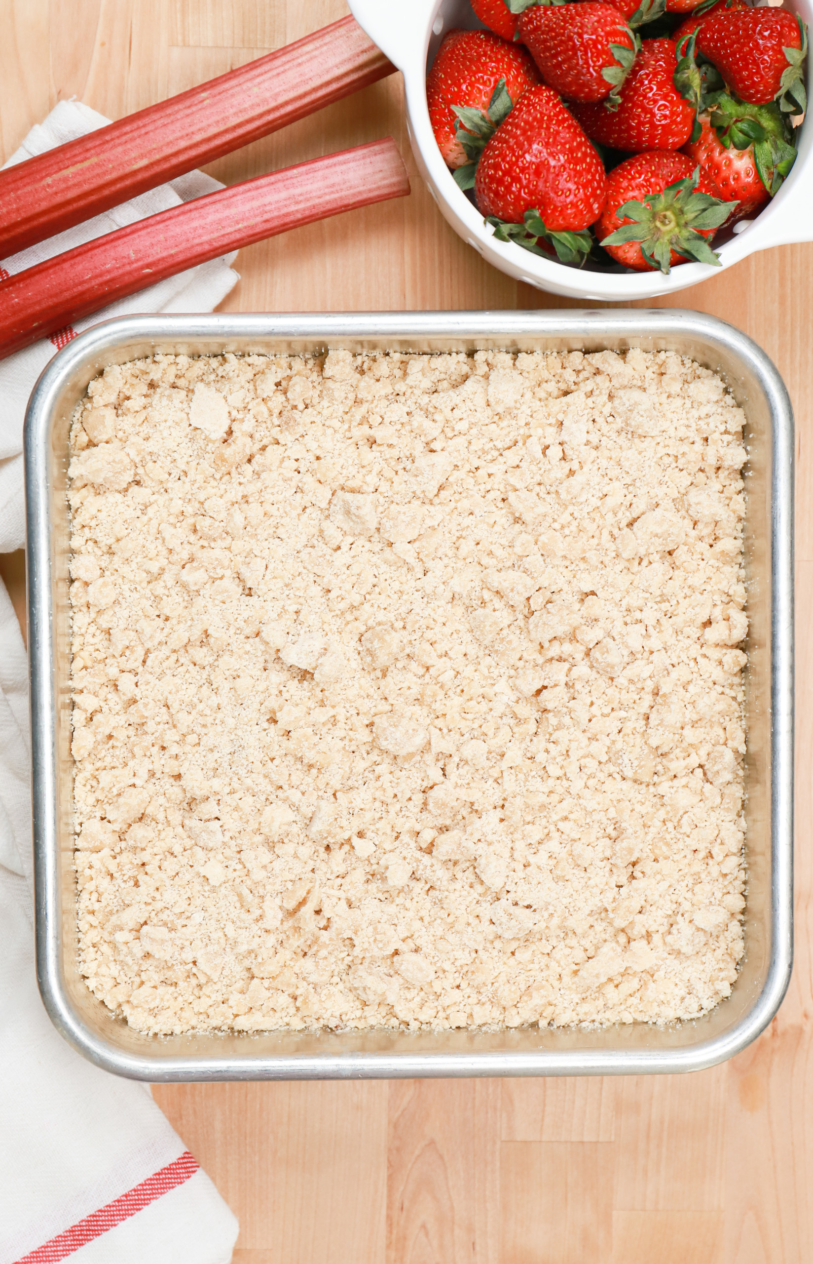 Overhead view of the crumb cake in an aluminum baking dish right before baking.