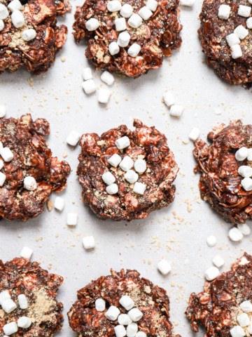 Close up overhead view of a batch of dark chocolate no bake cookies on a parchment paper lined baking sheet.