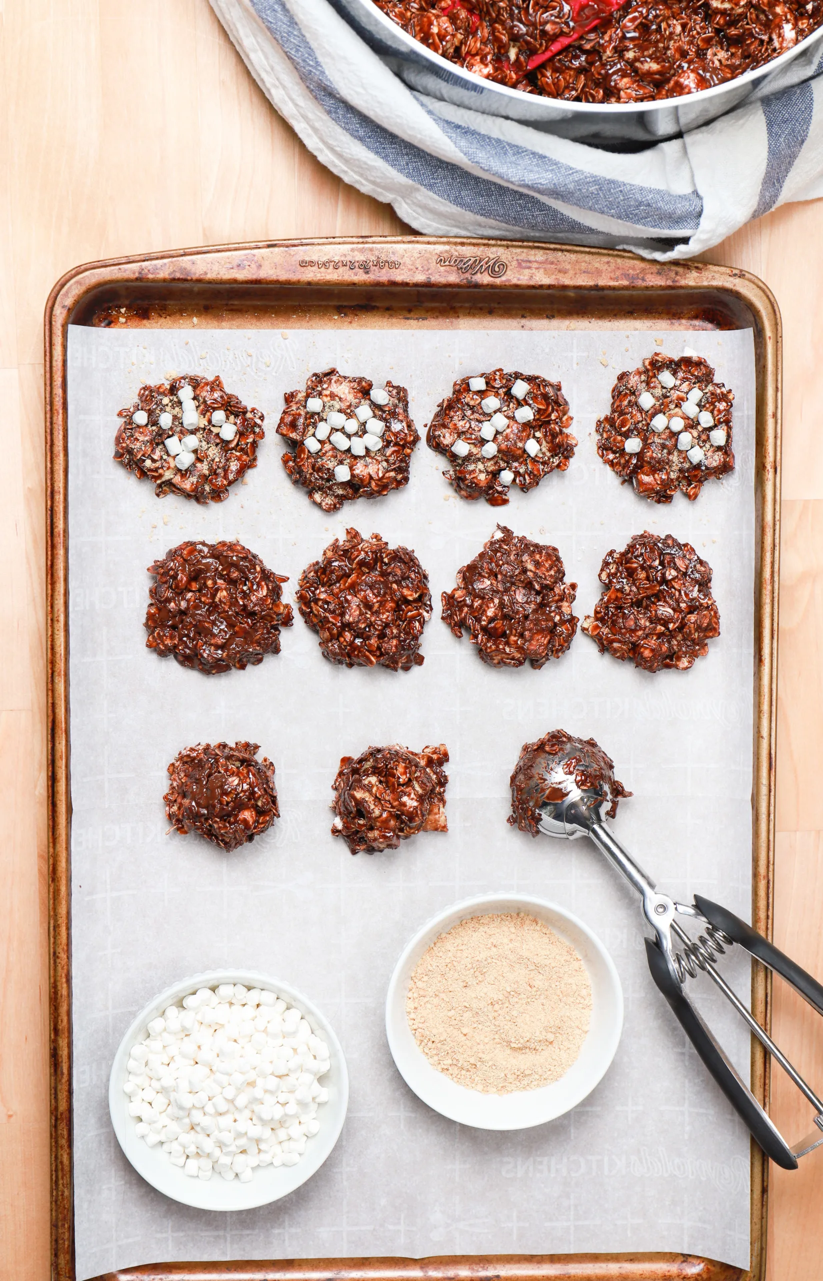 Dark chocolate smores no bake cookies in stages of doneness on a baking sheet.