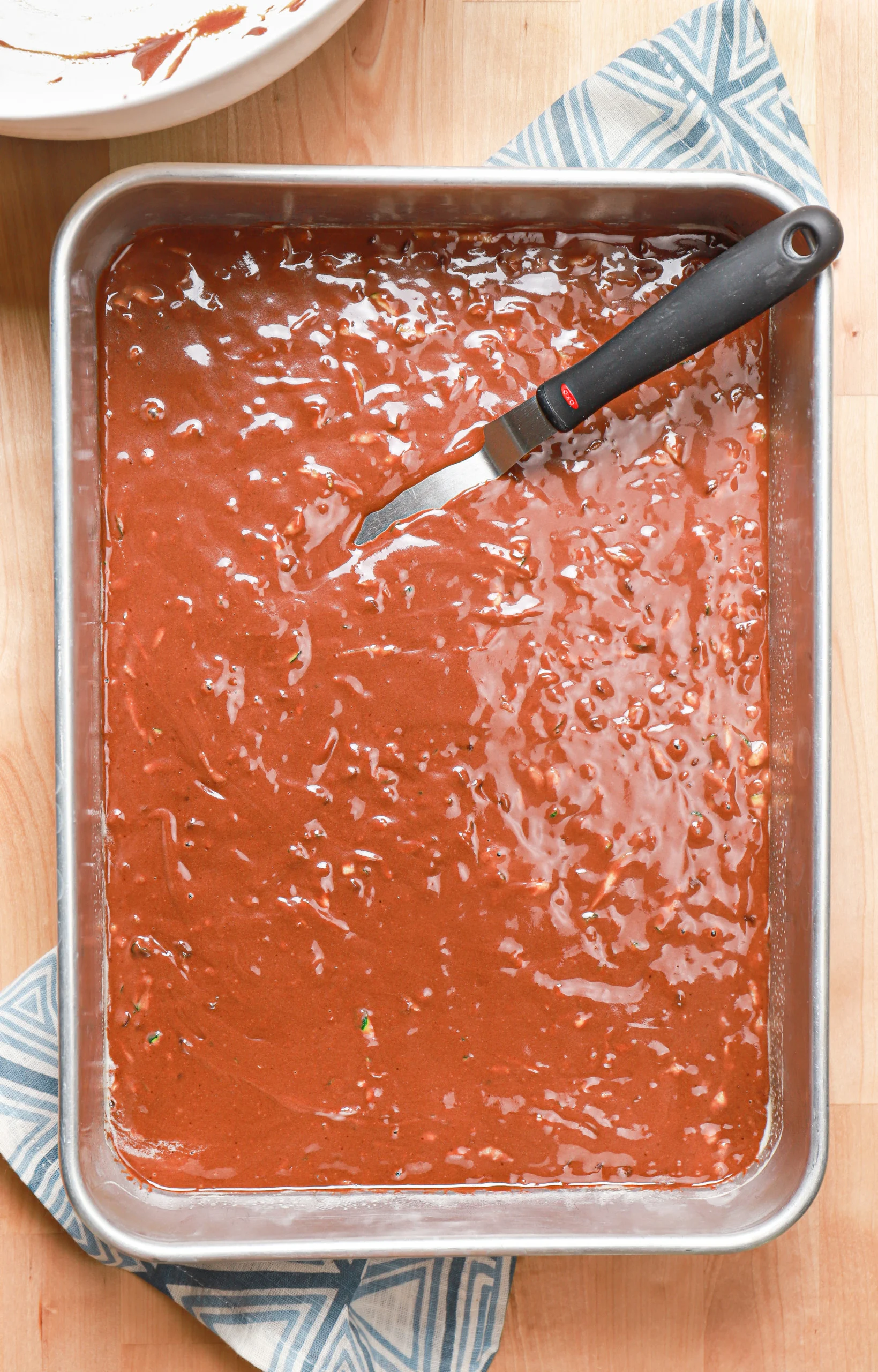 Overhead view of the chocolate zucchini bars batter in an aluminum baking dish before baking.