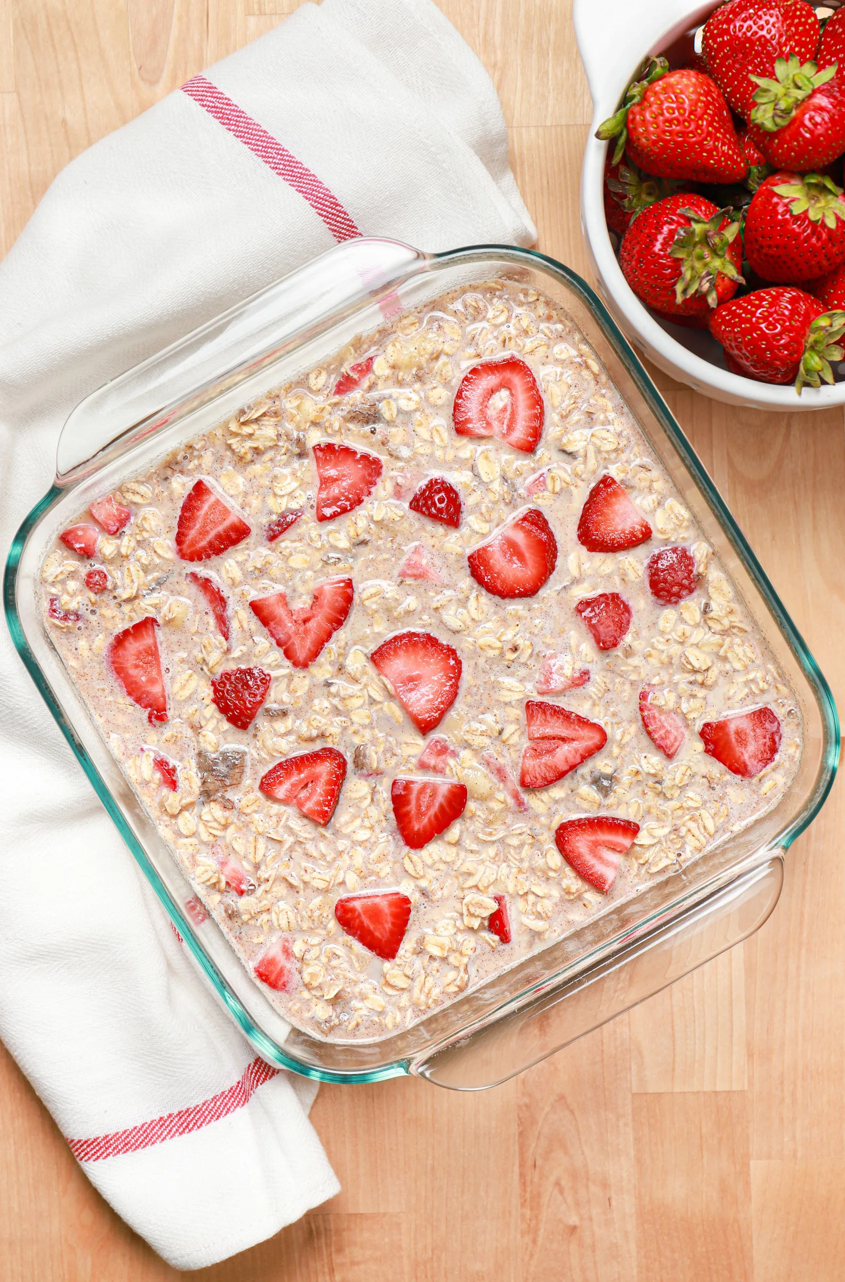 Overhead view of a baking dish of strawberry banana bread baked oatmeal before it is baked.