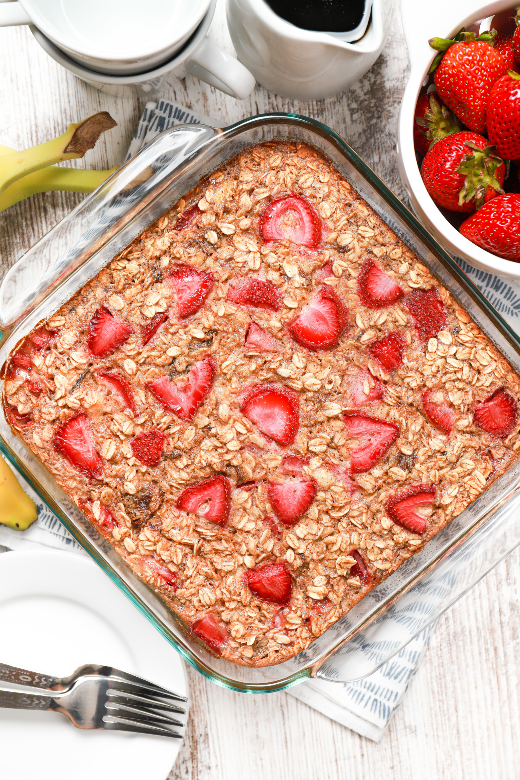 Overhead view of a batch of strawberry banana bread baked oatmeal in a glass baking dish fresh from the oven.