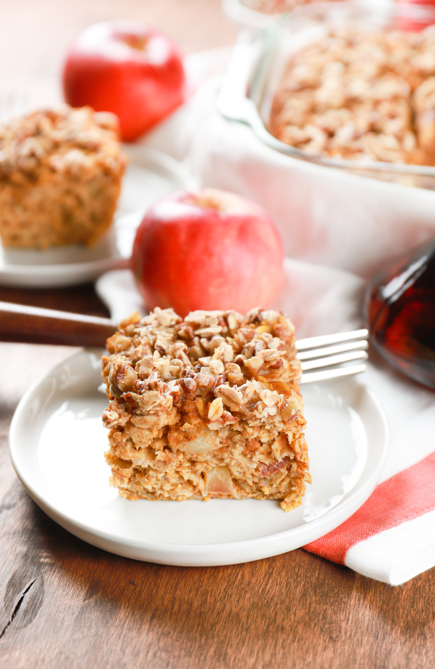 Side view of a slice of pumpkin apple baked oatmeal on a small white plate.