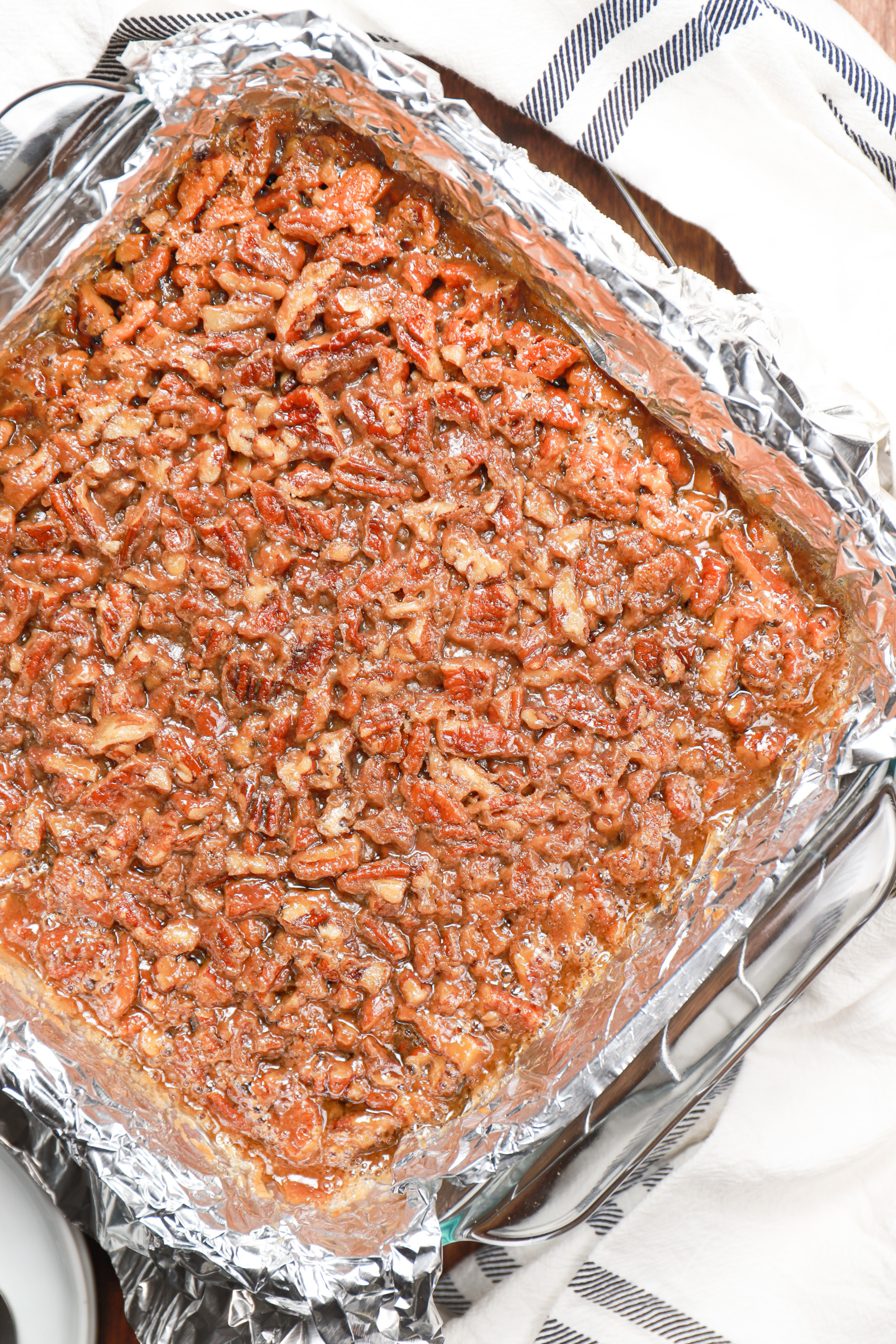 Overhead view of a batch of maple pecan pie bars right out of the oven on a wire cooling rack.