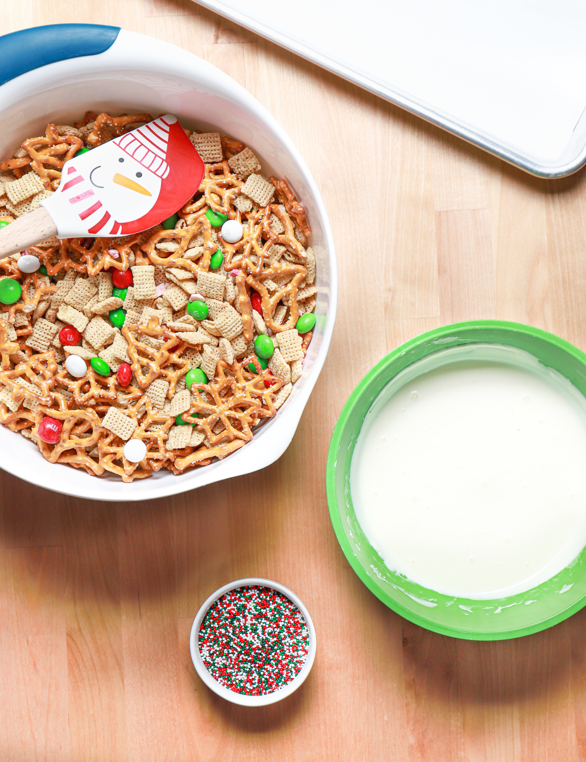 The ingredients for peppermint crunch snack mix on a wooden board.