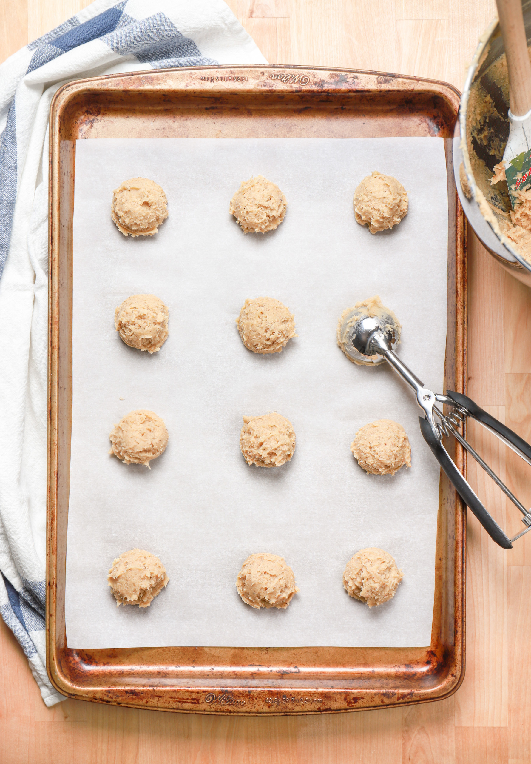 Overhead view of a batch of eggnog cookies on a cookie sheet before baking.