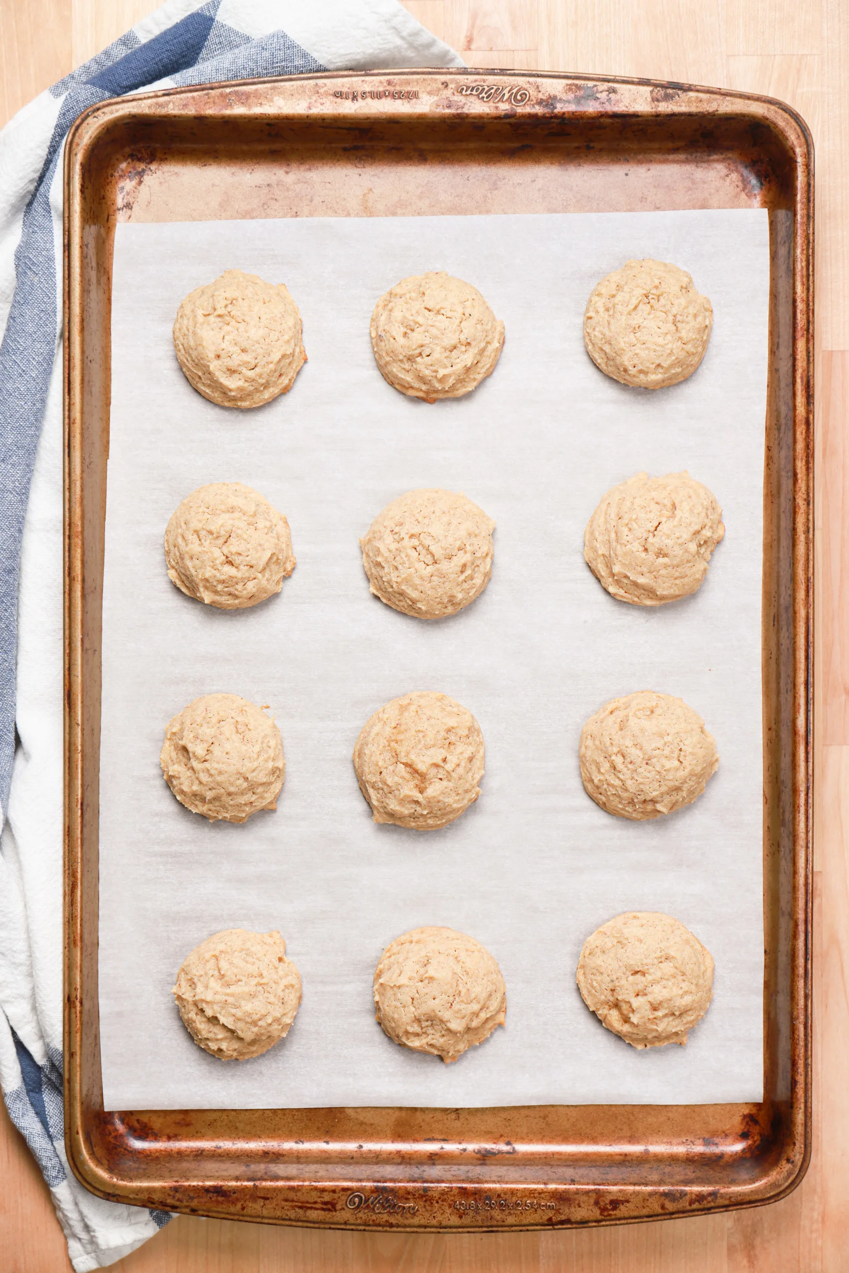 Overhead view of a batch of eggnog cookies on a cookie sheet right out of the oven.