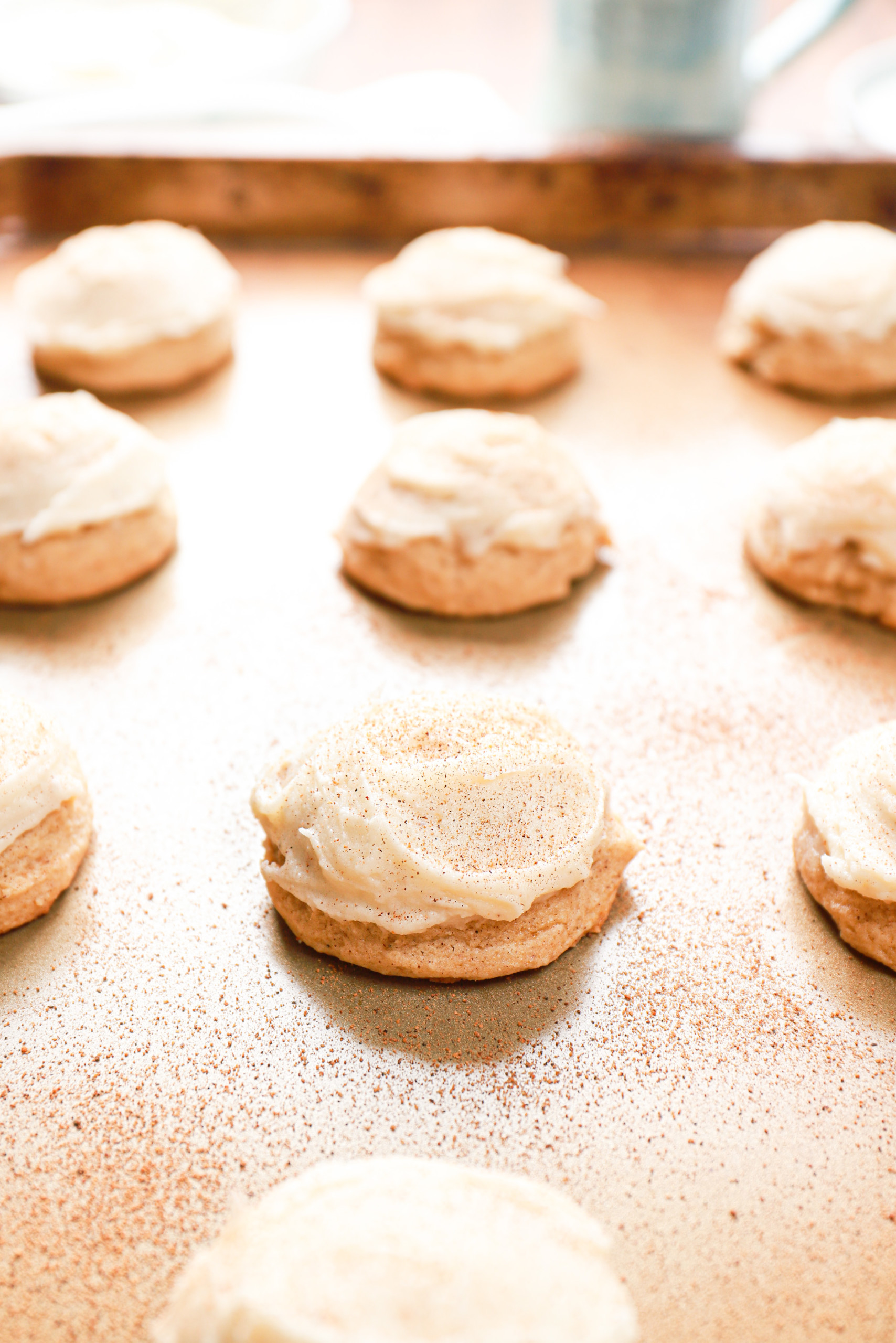 Up close side view of a frosted eggnog cookie on a baking sheet.