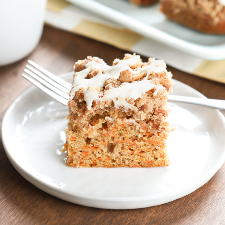 Up close side view of a piece of carrot cake coffee cake on a small white plate.