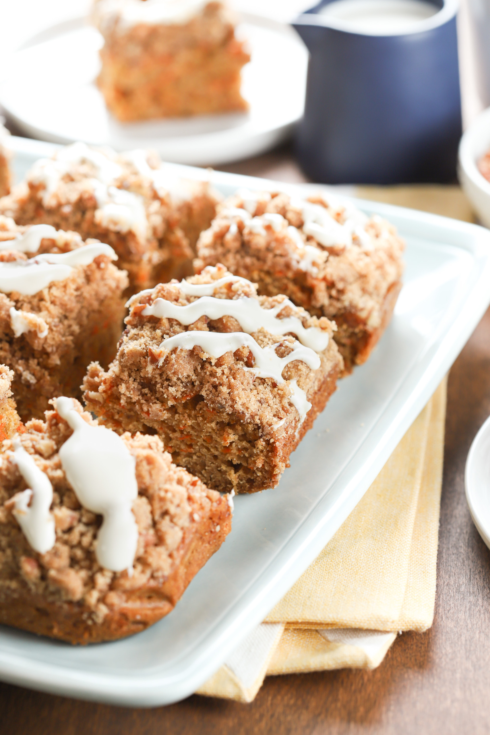 Side view of a piece of carrot cake coffee cake on a light blue plate.