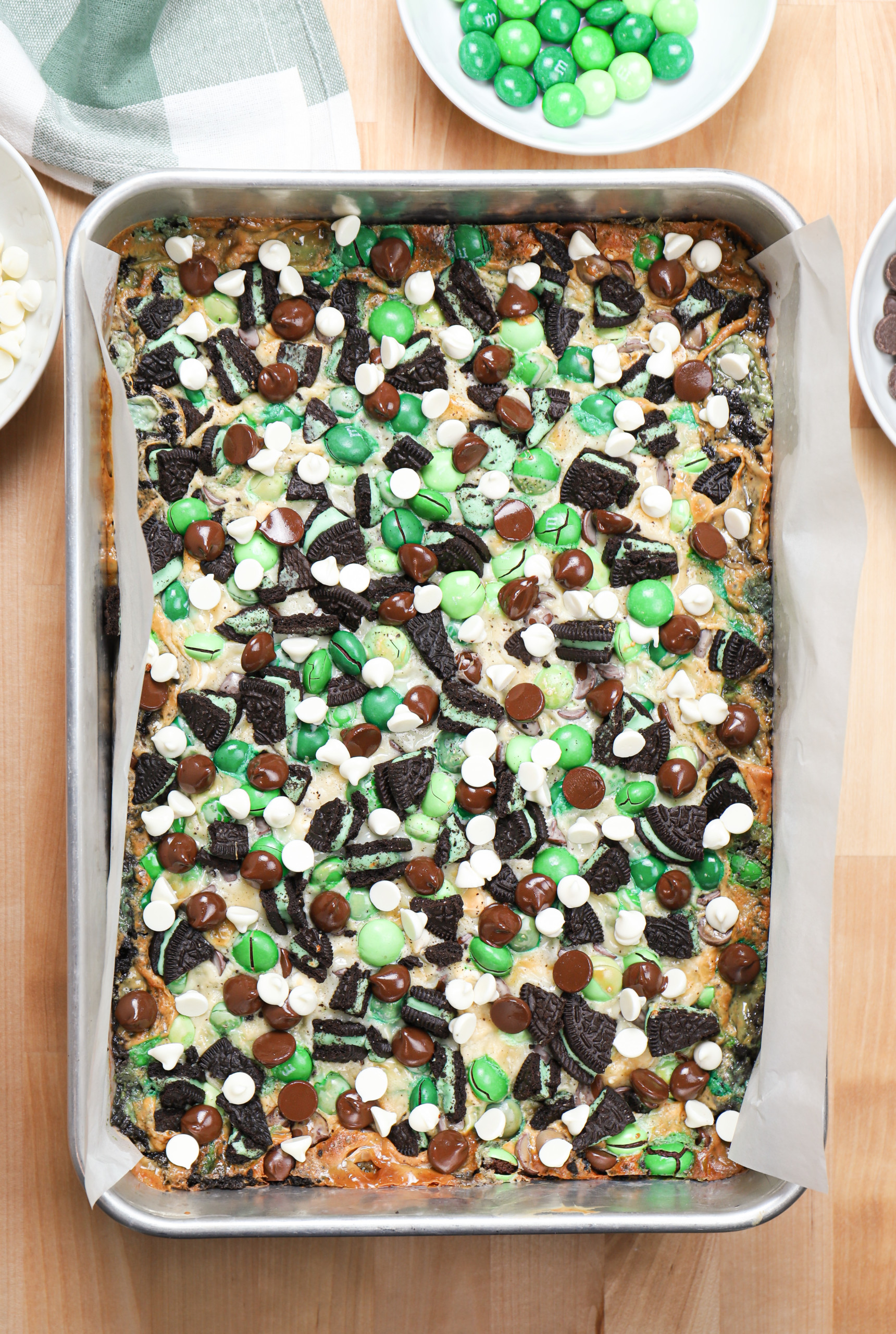 Overhead view of a batch of mint chocolate seven layer bars right out of the oven before cutting into pieces.