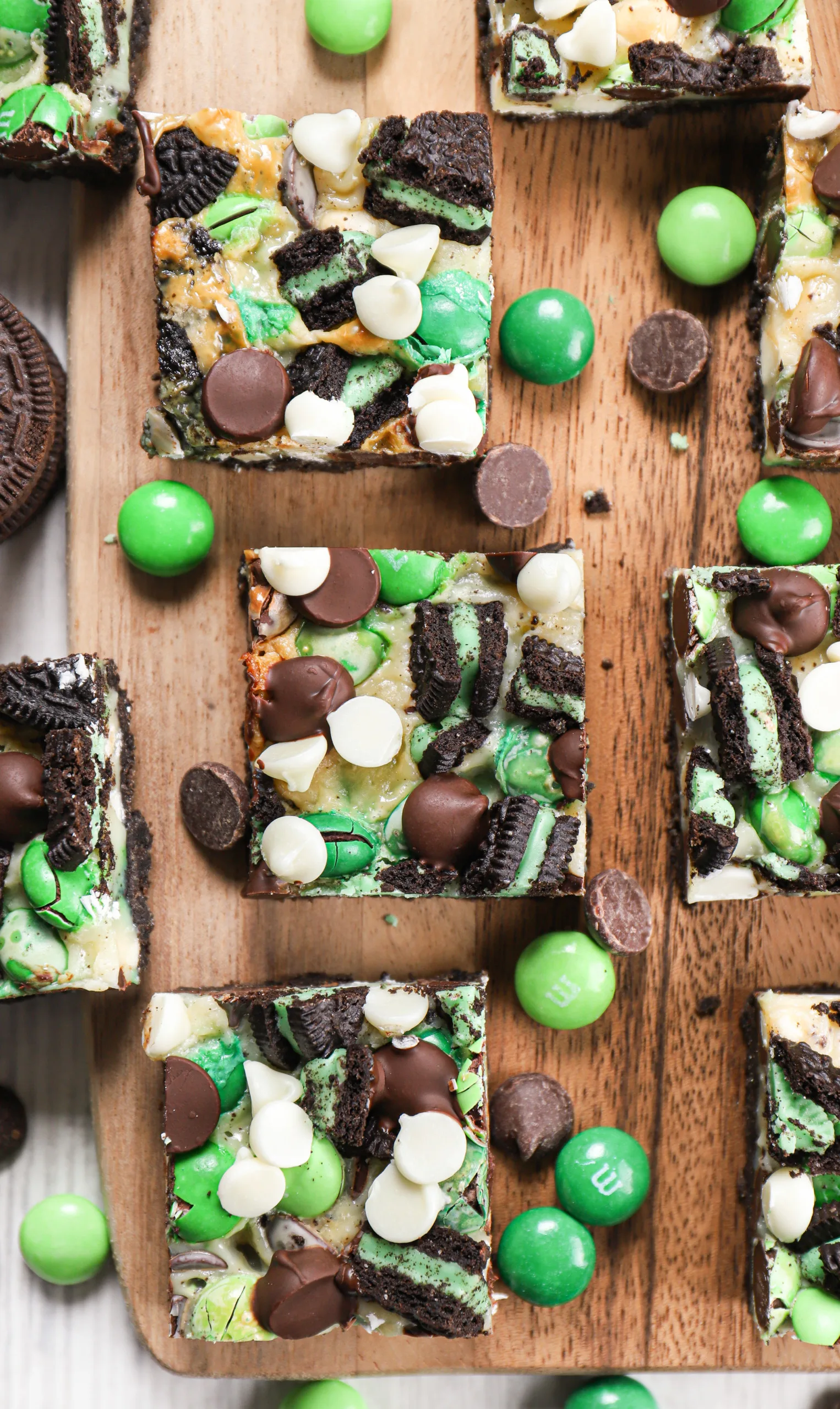 Up close overhead view of a mint chocolate magic bar on a wooden cutting board with other bars surrounding it.