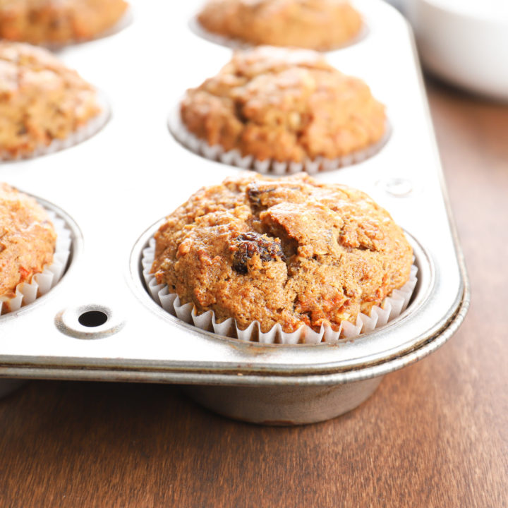 Up close side view of a morning glory muffin in an aluminum muffin tin.