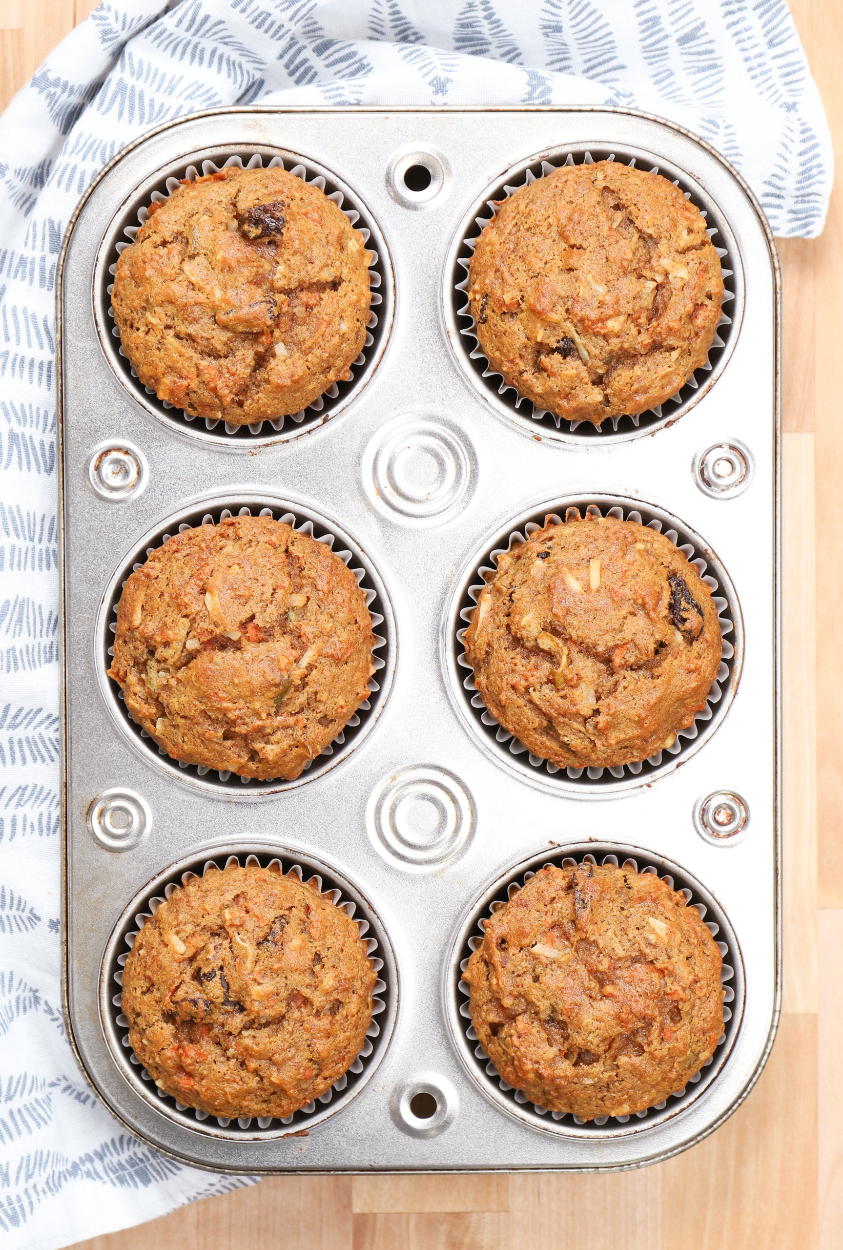 Overhead view of a batch of morning glory muffins right out of the oven still in the muffin tin.