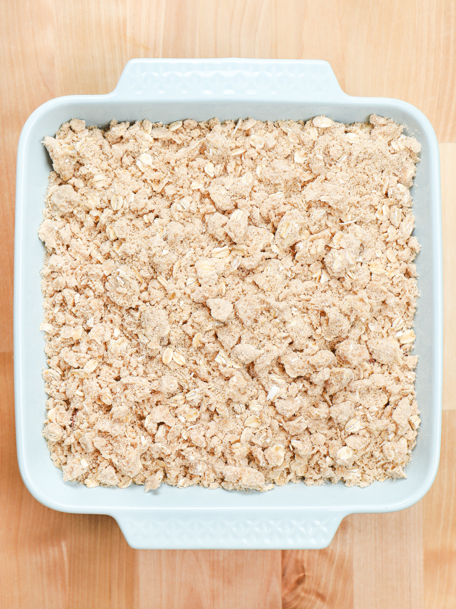 Overhead view of a dish of strawberry rhubarb crisp before it is baked.