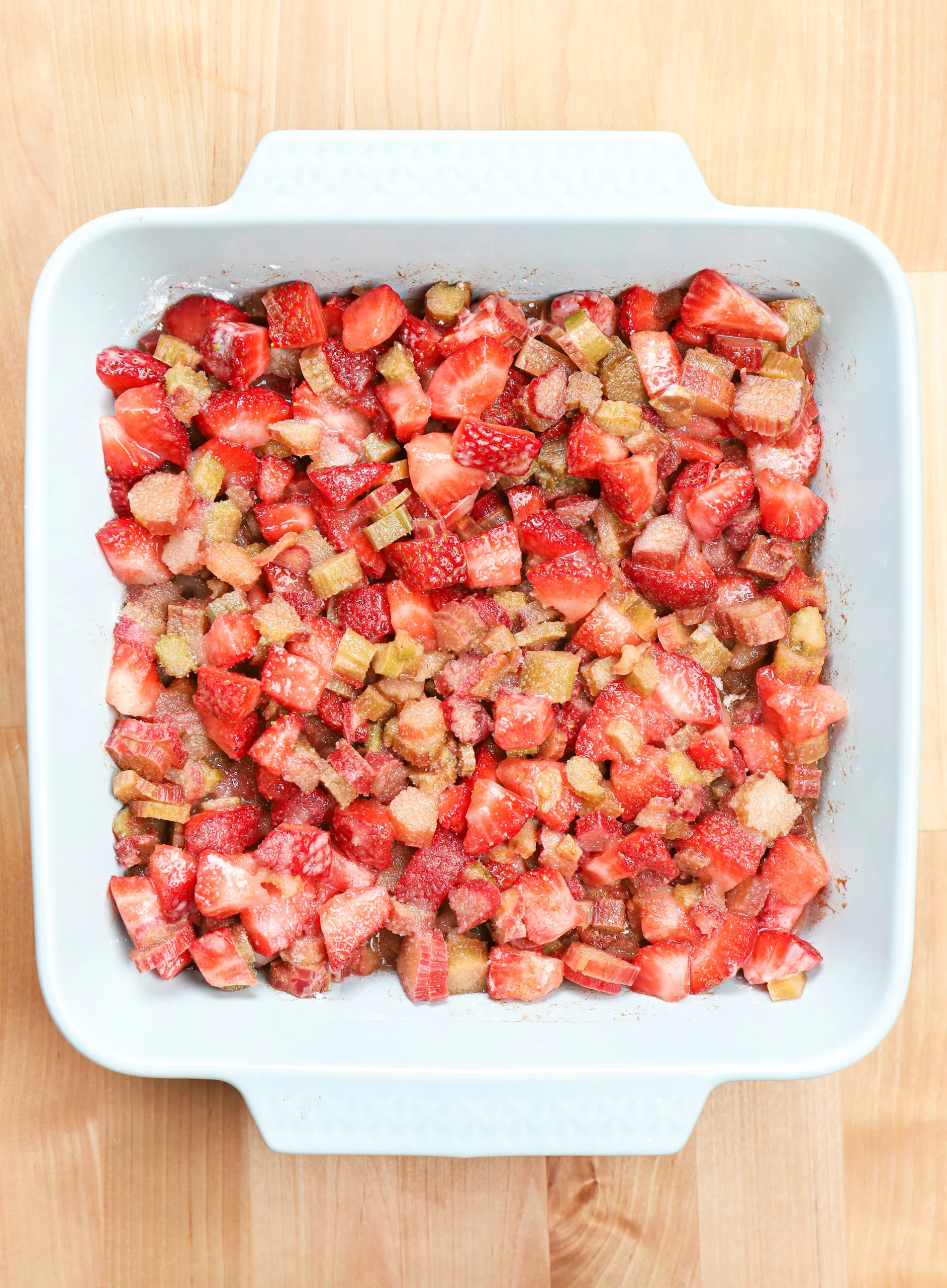 Overhead view of a dish of strawberry rhubarb crisp without the crisp topping.