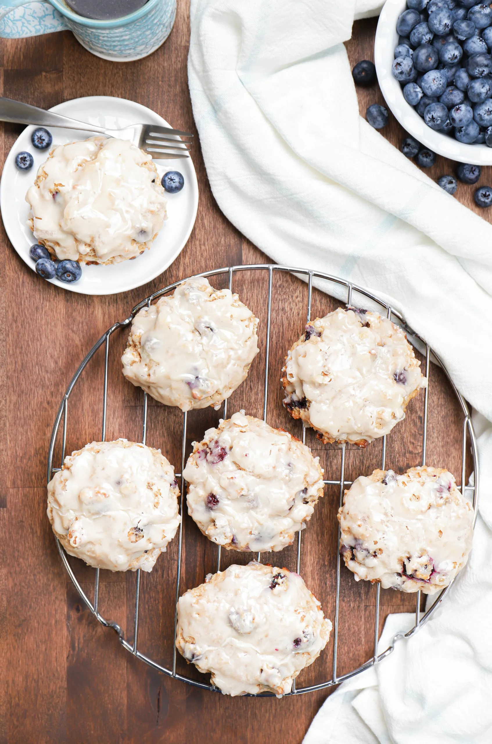 Overhead view of a batch of baked blueberry fritters on a cooling rack.