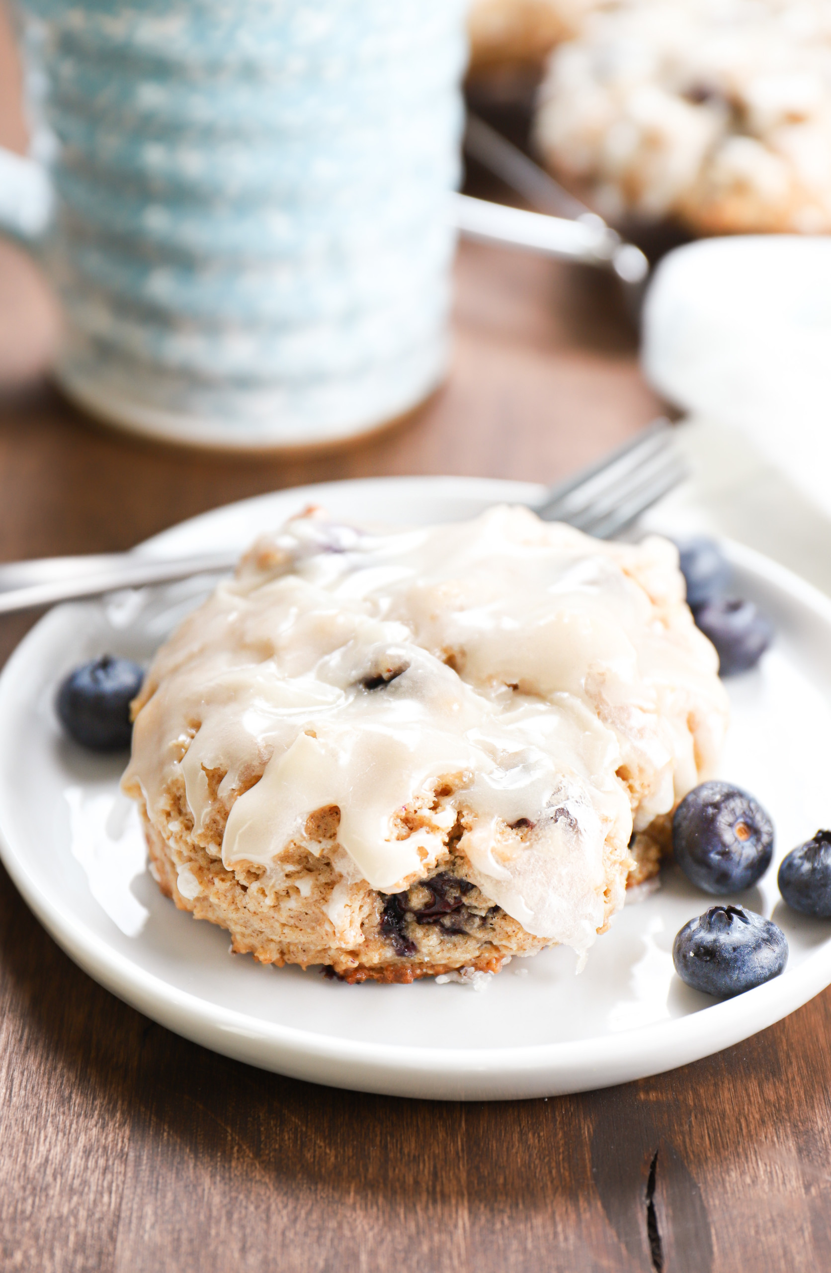 Baked blueberry fritter on a small white plate.