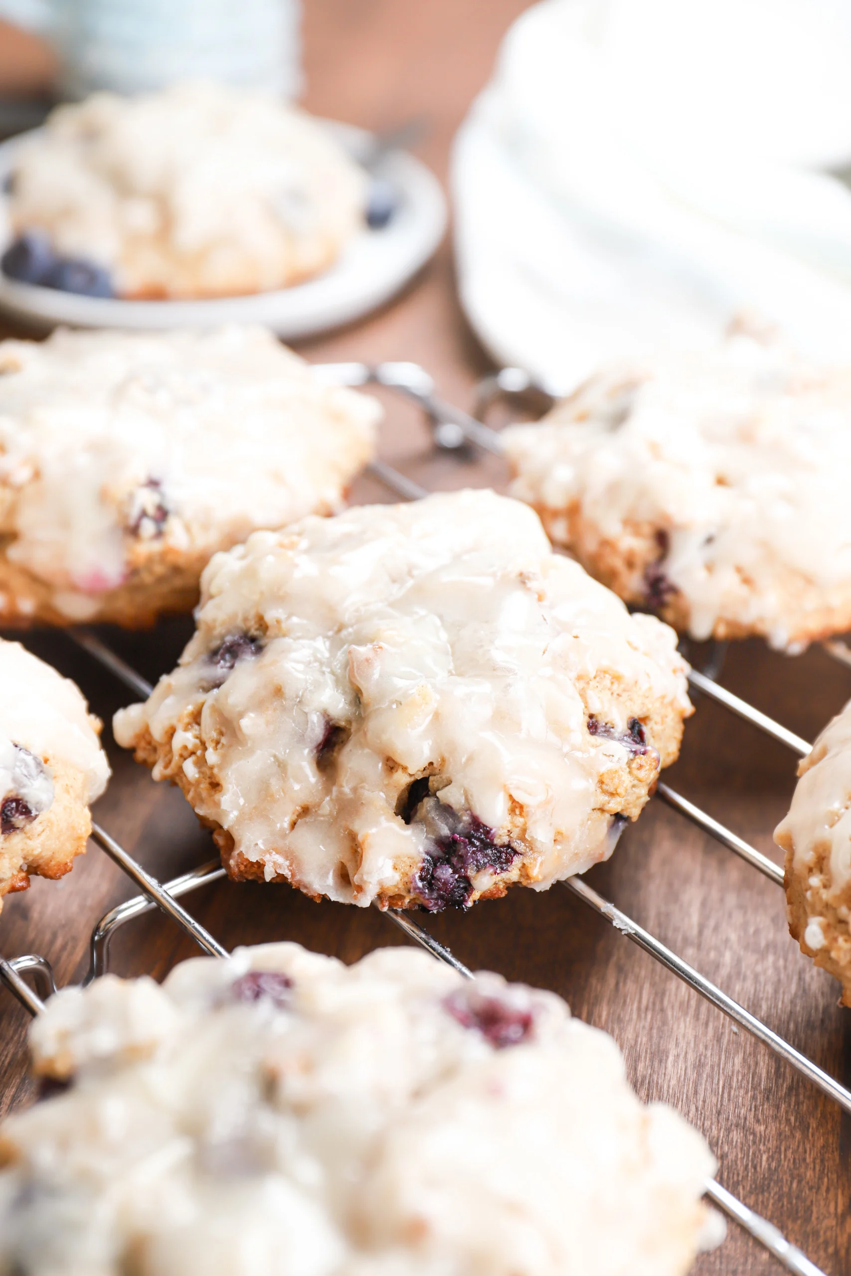 Up close view of a baked blueberry fritter on a cooling rack surrounded by other fritters.