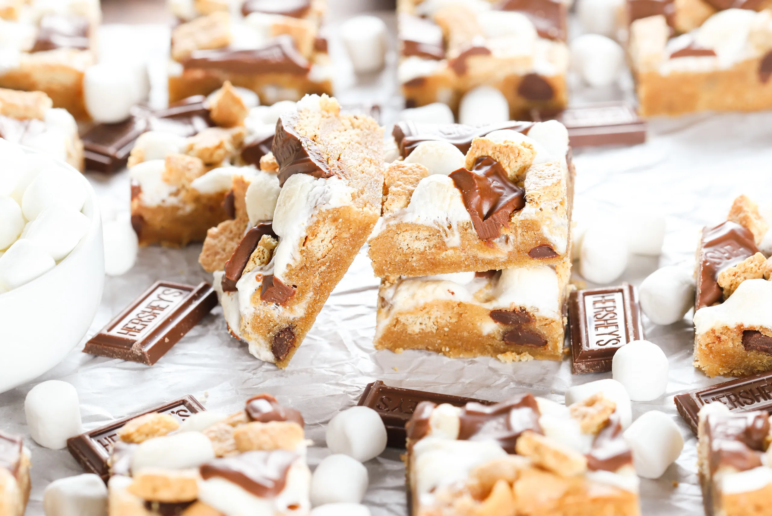 Up close side view of a peanut butter smores bar leaning up against a stack of two bars.