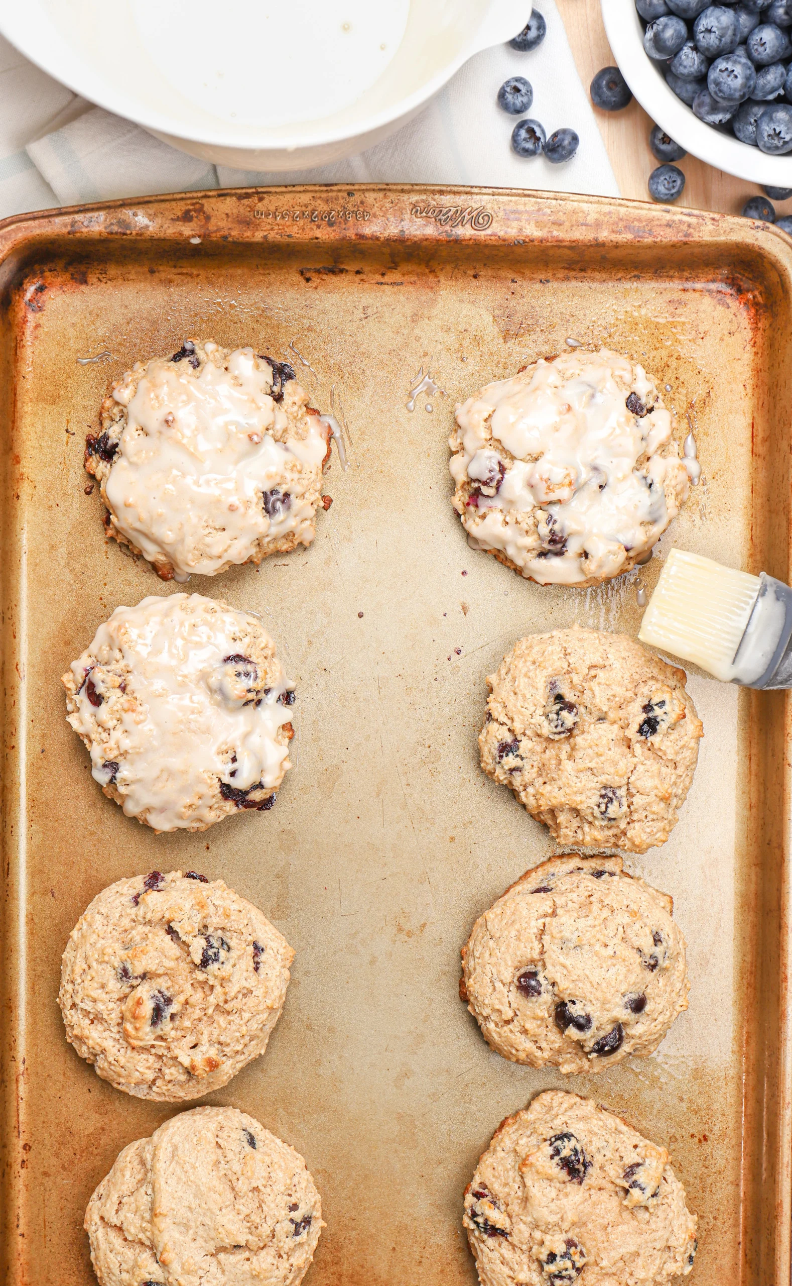 Overhead view of putting a confectioner's sugar glaze on the blueberry fritters.