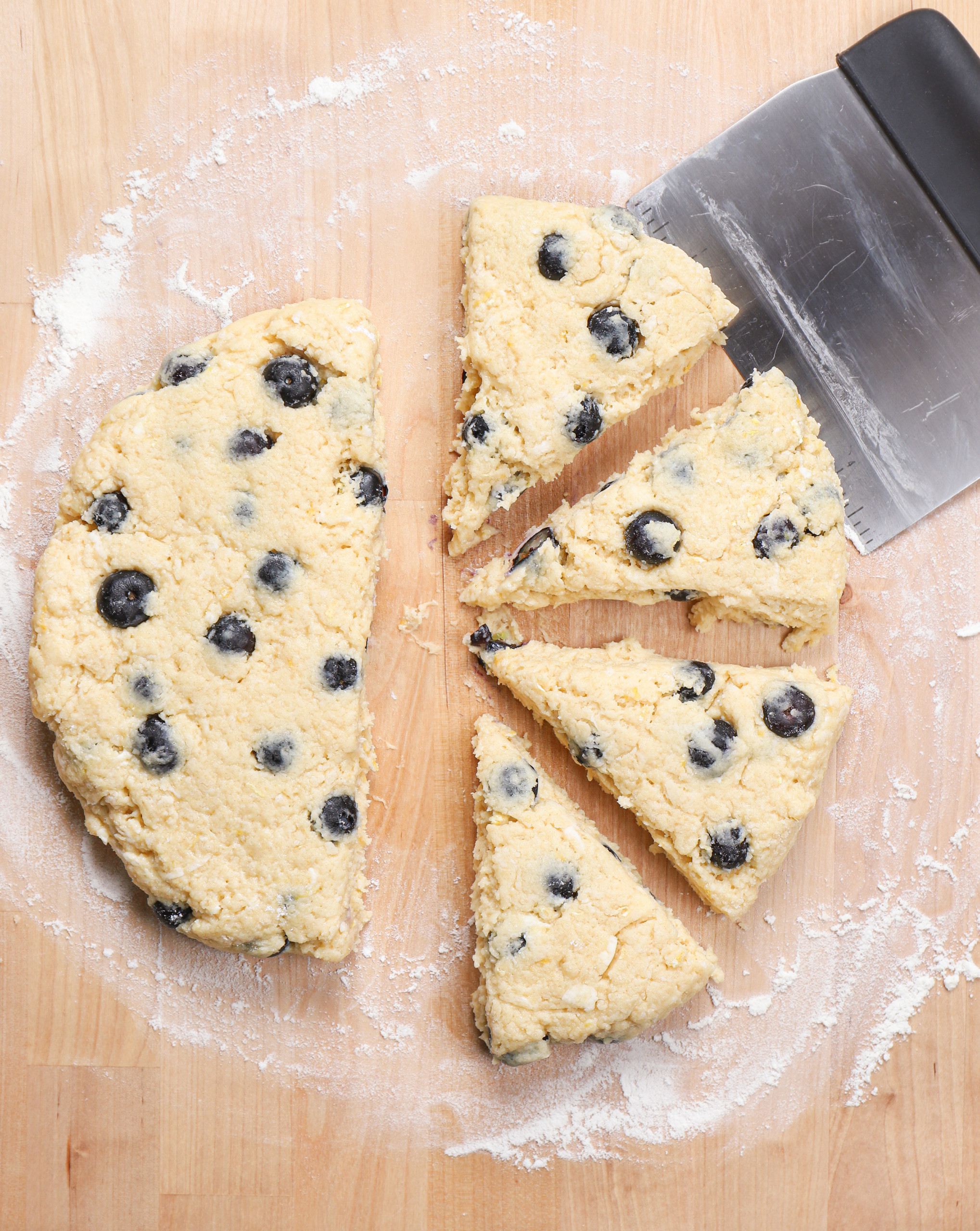 Overhead view of the circle of scone dough cut into half and into pieces.