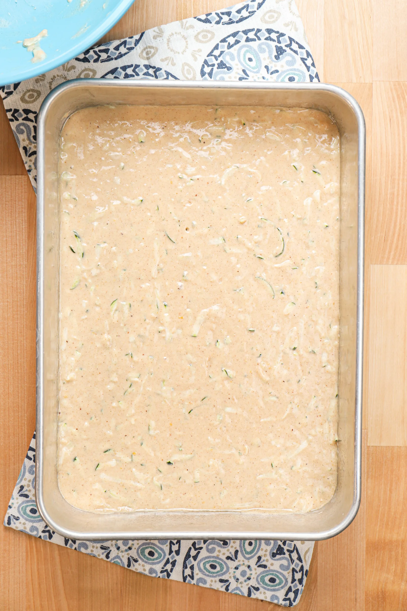 Overhead view of a pan of zucchini bars before baking.